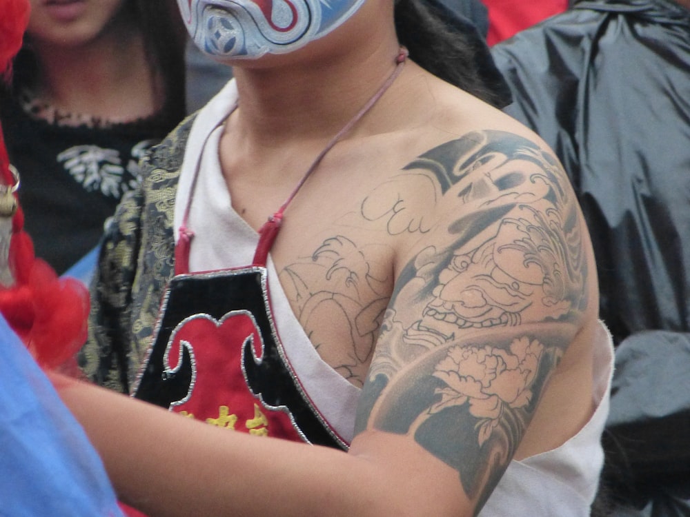 woman in white tank top with tattoo on her chest