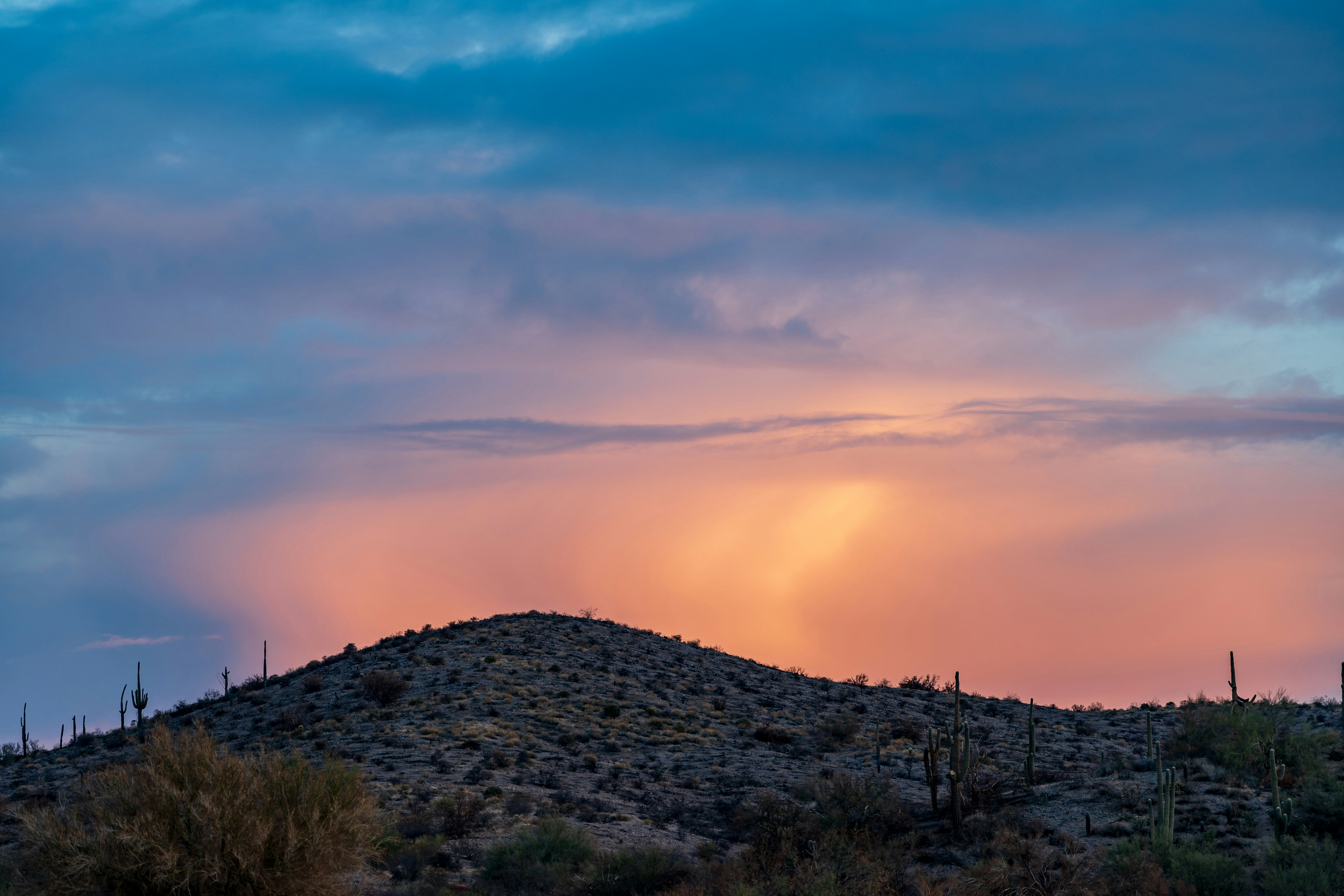 green grass field under cloudy sky during daytime