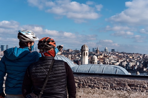 man in black jacket and helmet standing on top of the building during daytime