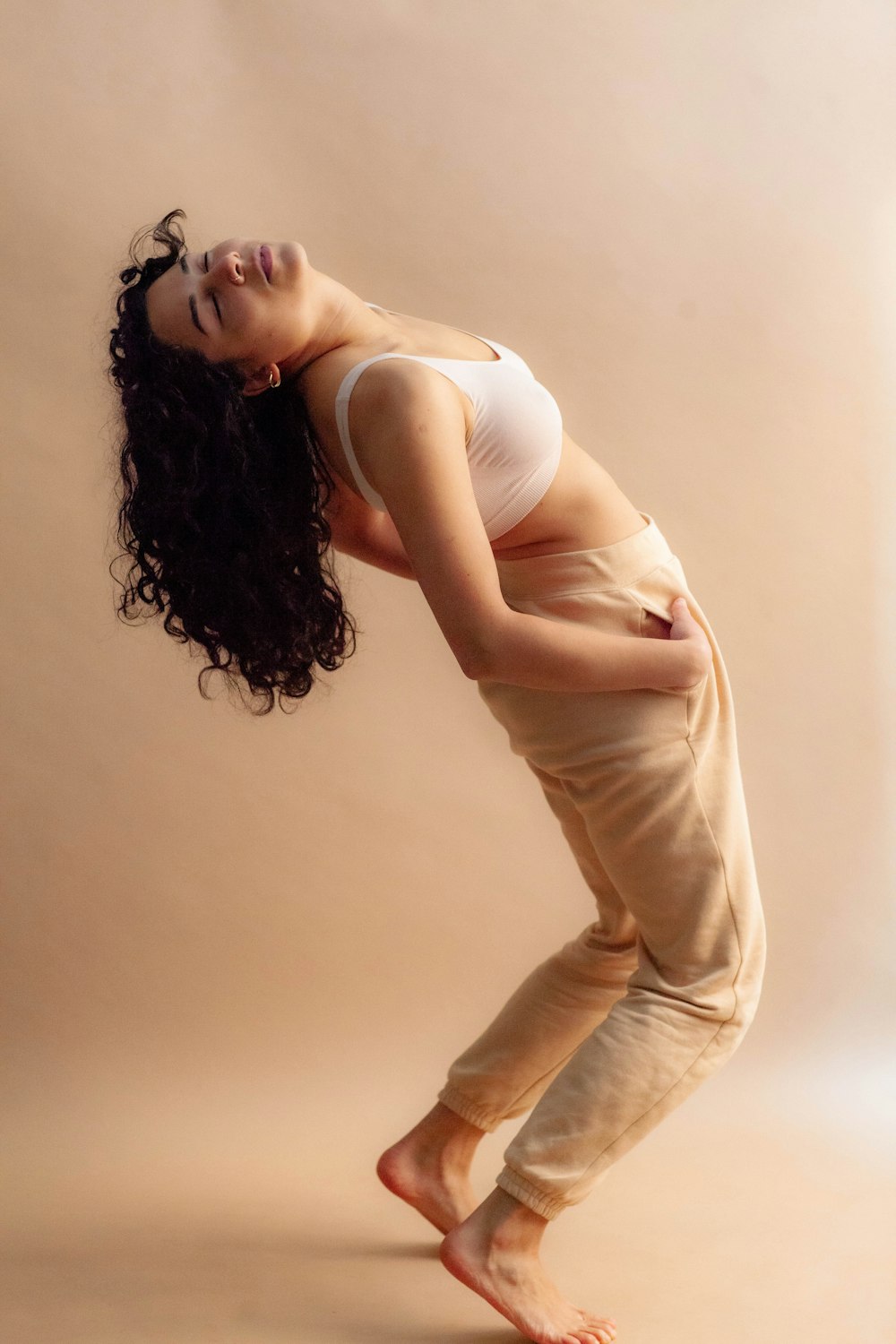 woman in white tank top and beige pants