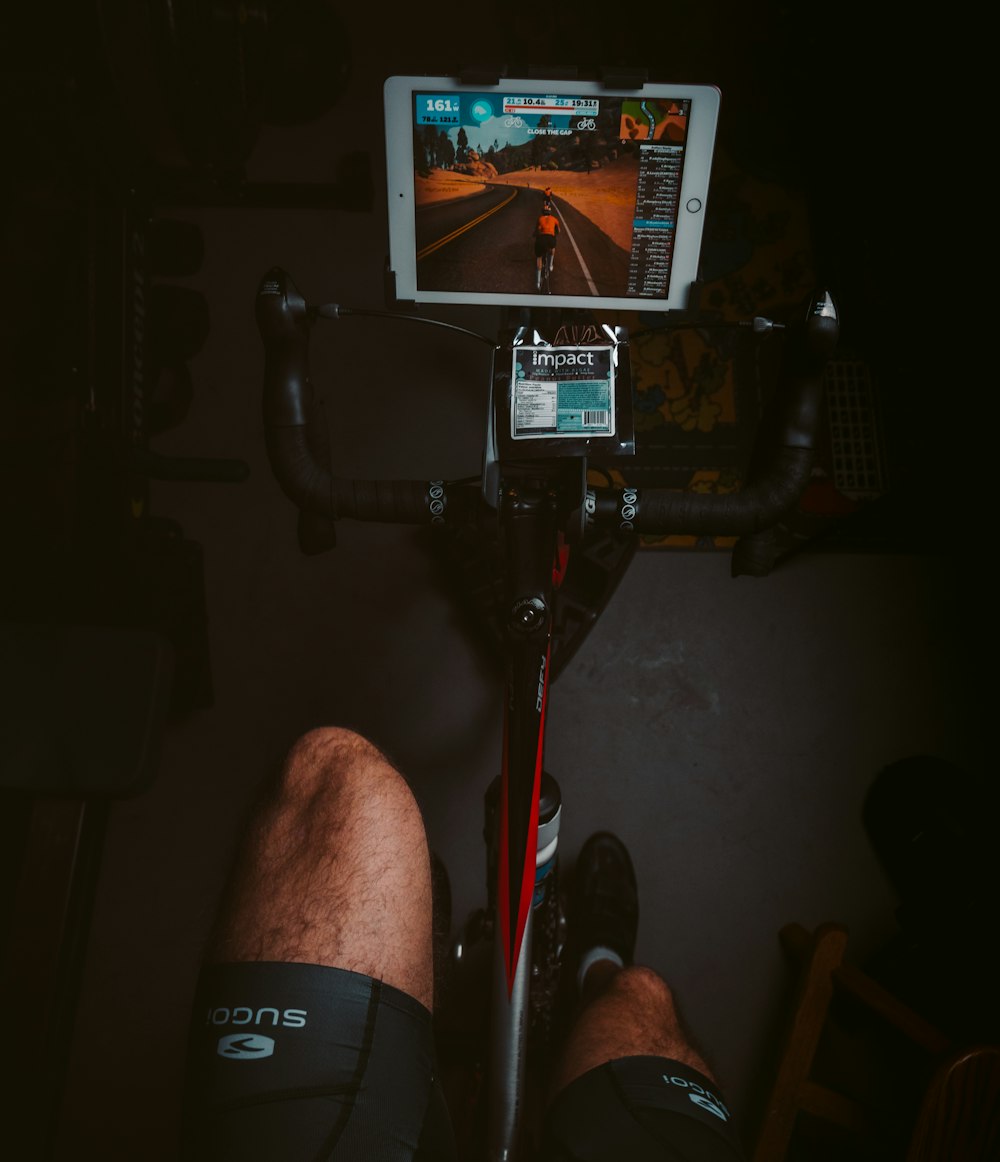 person in black shorts sitting on black and red stationary bike