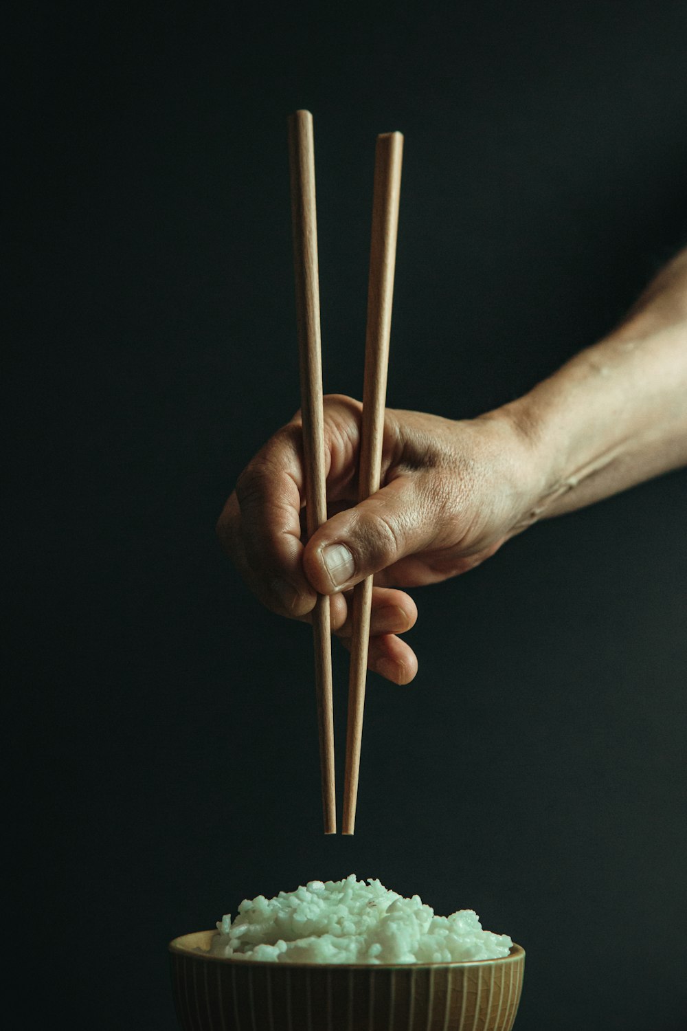 person holding brown wooden sticks