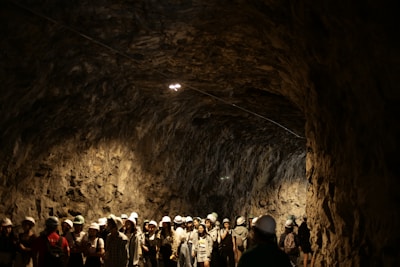 A group of adventurers exploring a sunlit cave in Cantabria, equipped with helmets and headlamps.