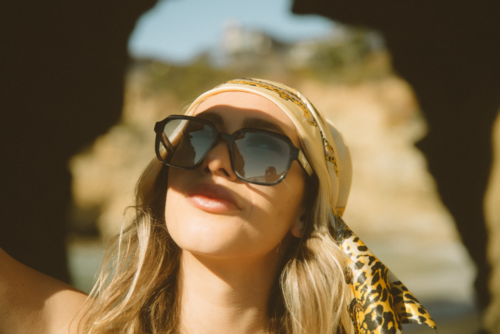 woman in brown and black leopard print shirt wearing black sunglasses