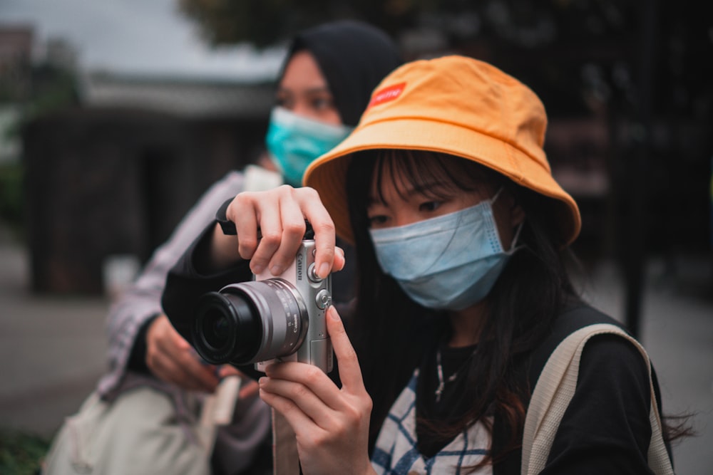 woman in brown jacket holding black camera