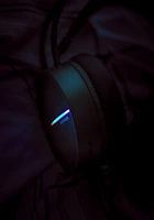 A vibrant close-up of a sleek wireless headphone set glowing softly against a dark background.