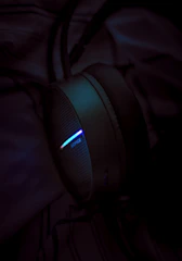 Close-up of headphones and smartwatches glowing under soft lighting.