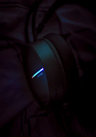 A close-up of t1 wireless headset controls glowing softly in a dim room.