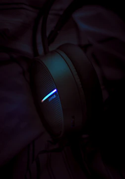 Close-up of headphones and smartwatches glowing under soft lighting.