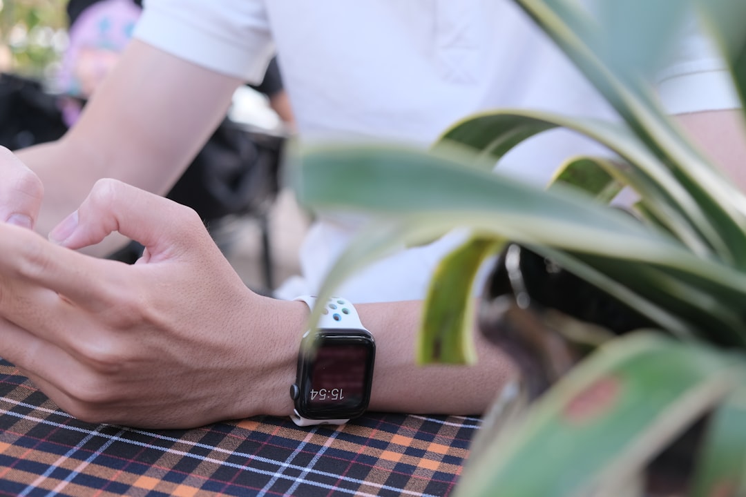 person wearing silver aluminum case apple watch with white sport band