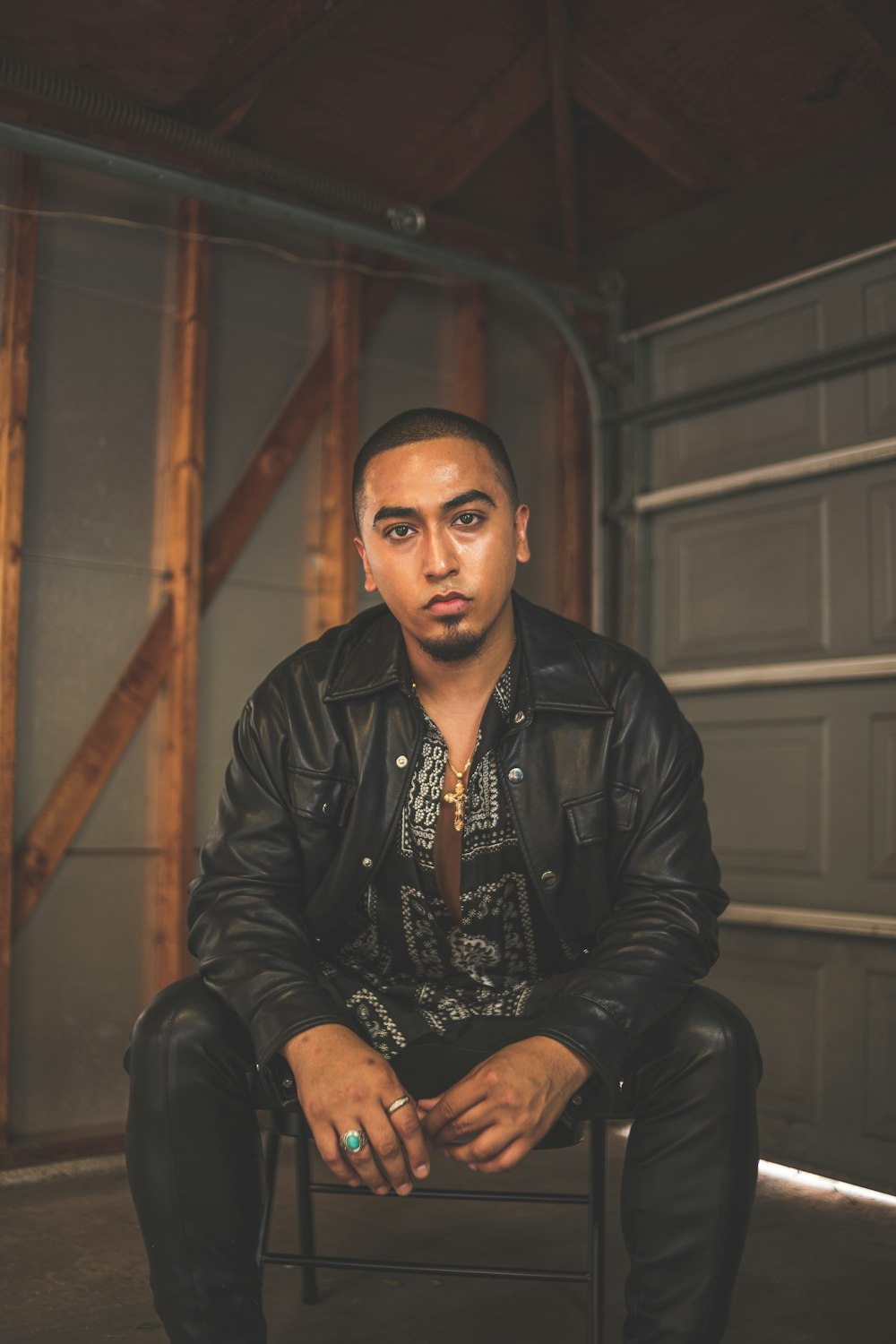 man in black leather jacket sitting on chair