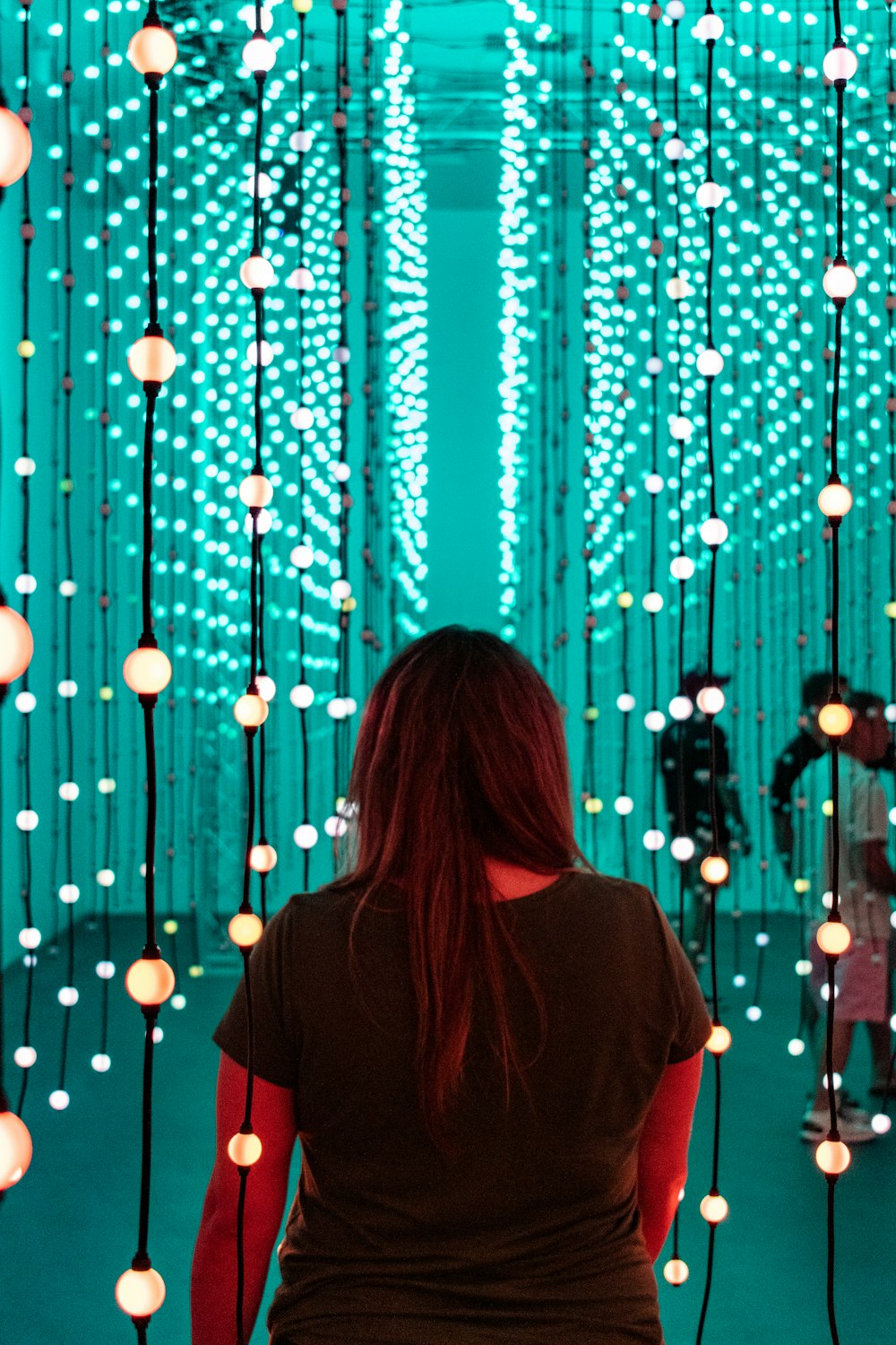woman in red shirt standing in front of blue lights
