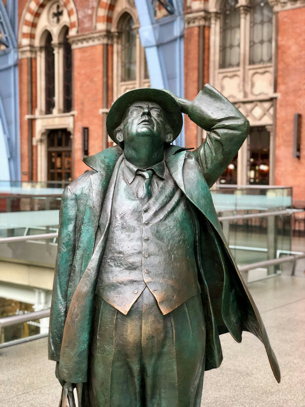 green statue of man holding book