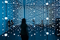 silhouette of woman standing in front of blue lights