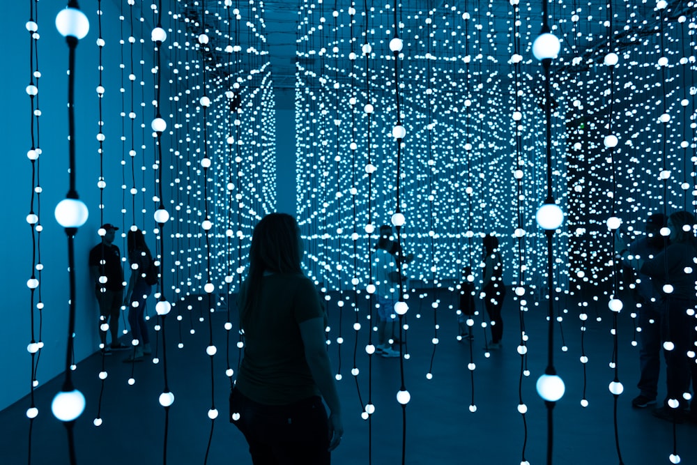 silhouette of woman standing in front of blue lights