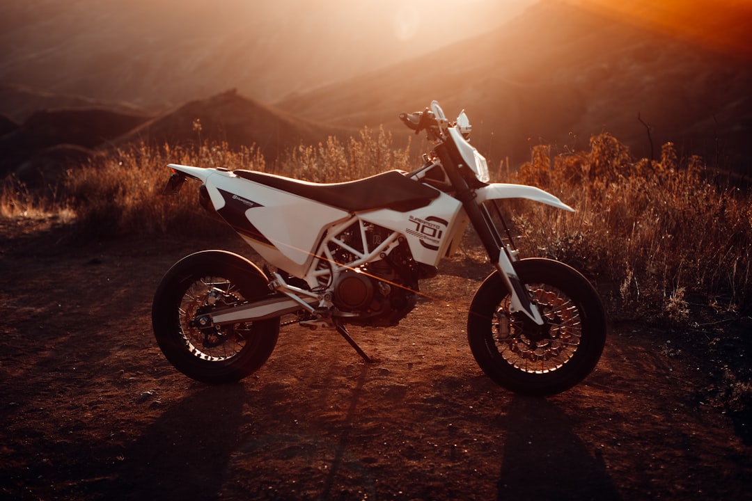 white and black sports bike on brown field during daytime