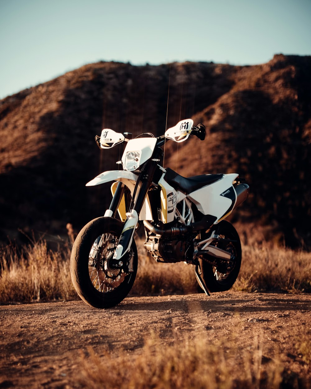 white and black sports bike on brown grass field during daytime