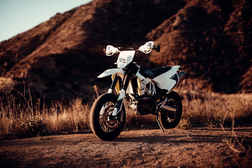 white and black sports bike on brown field during daytime