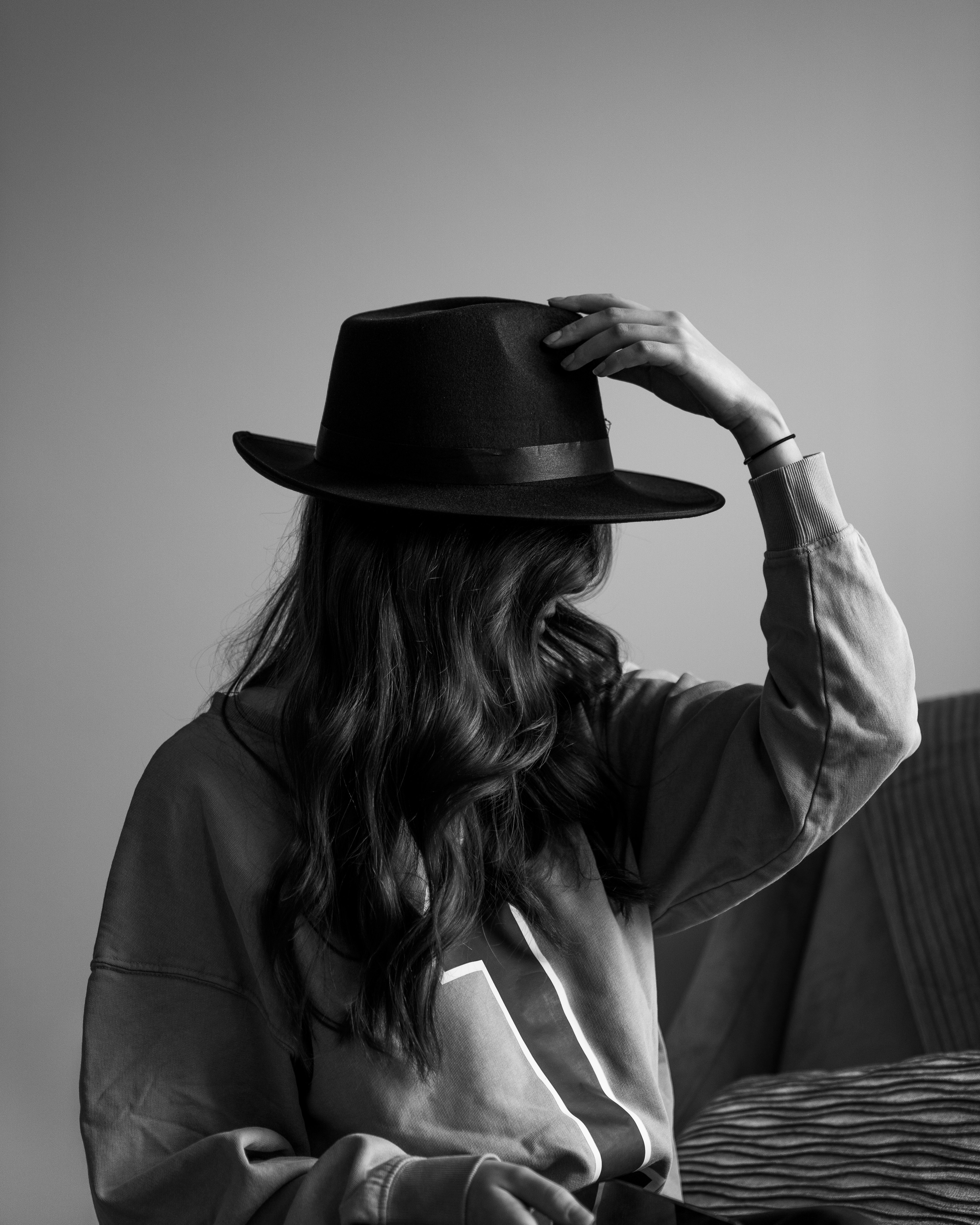 woman in gray long sleeve shirt wearing black fedora hat