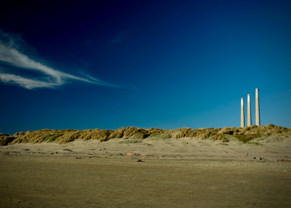 white and brown lighthouse on brown sand under blue sky during daytime
