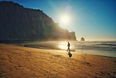 person in black shirt and pants walking on beach during daytime determined google meet background