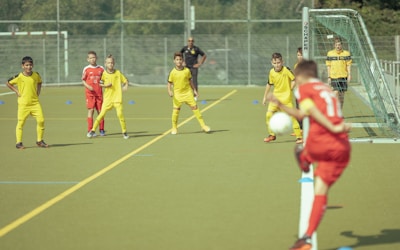 group of men playing soccer during daytime