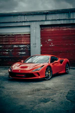 red ferrari 458 italia parked beside red wall