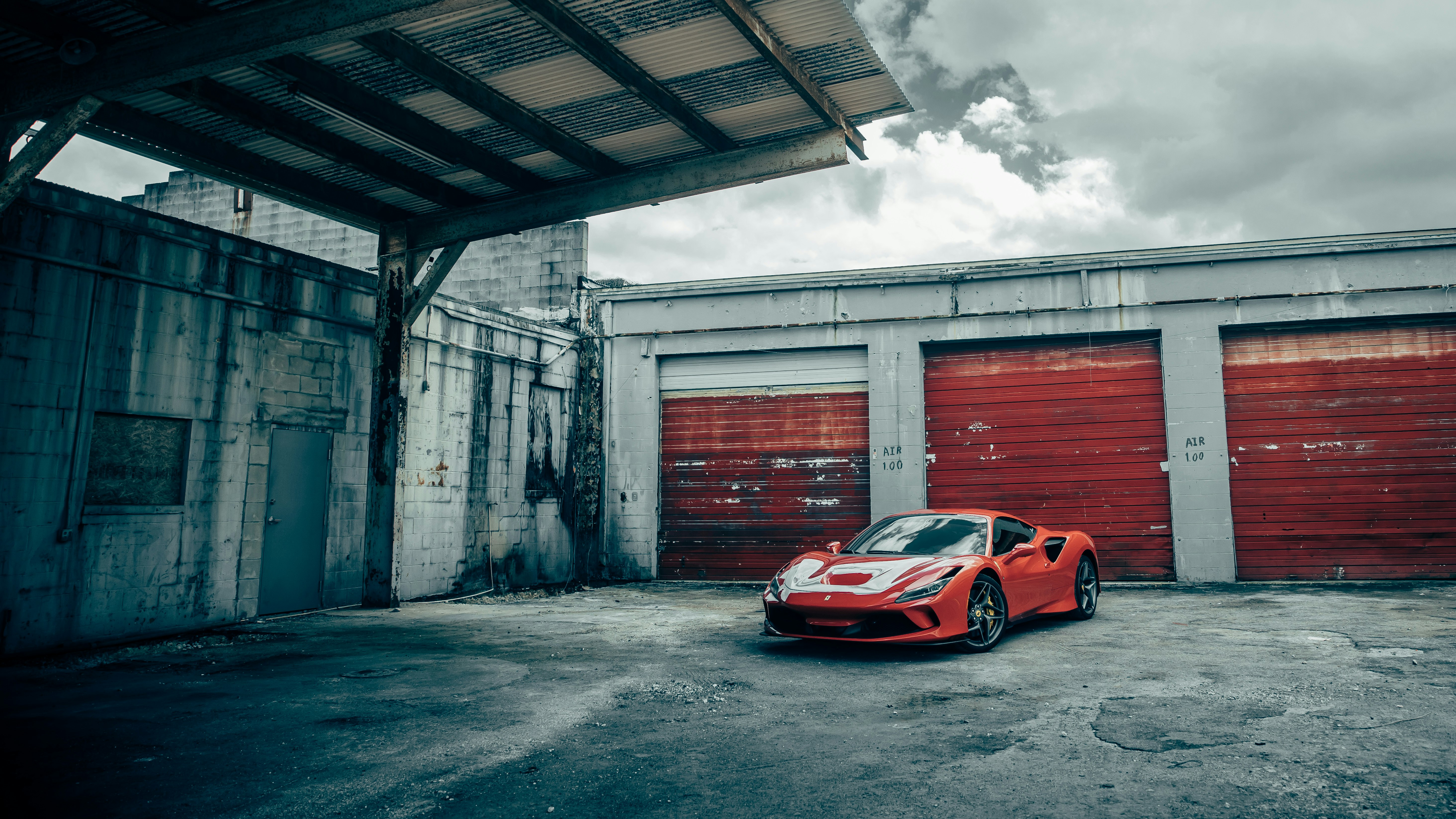 red and white porsche 911 parked beside gray concrete building during daytime