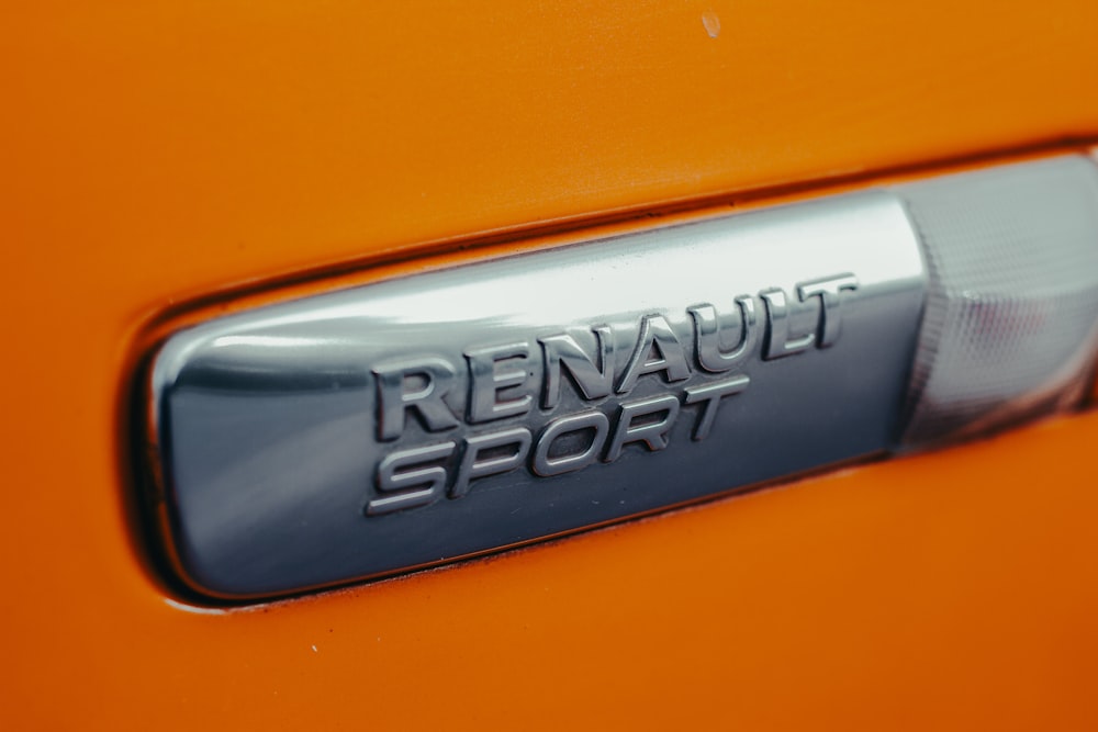 a close up of a sports badge on an orange sports car