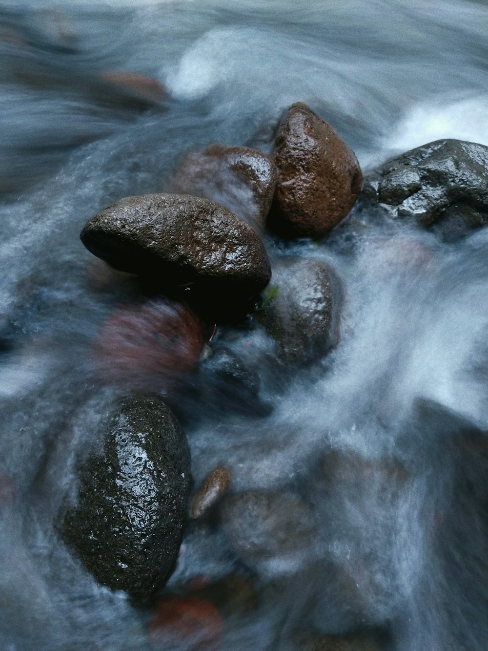 black rocks on body of water