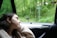A happy customer using a travel pillow in a car.