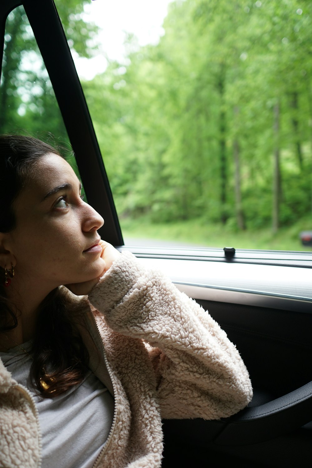 woman in white fur coat sitting inside car during daytime