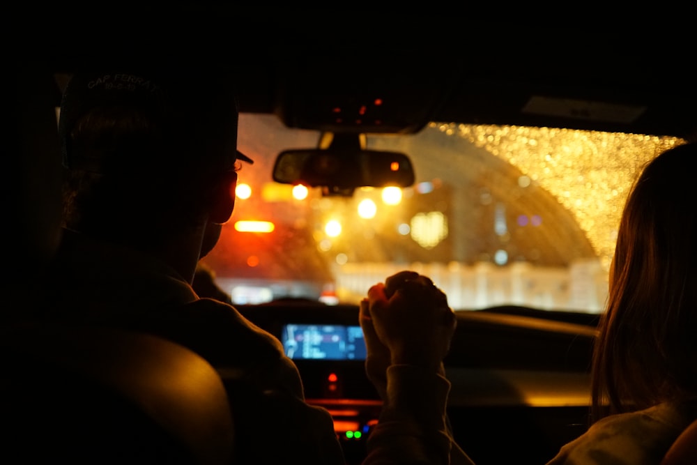 man in black jacket driving car during night time