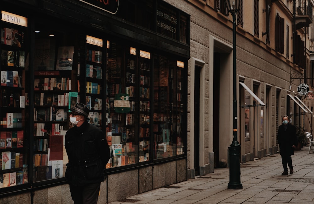 woman in black coat standing near store