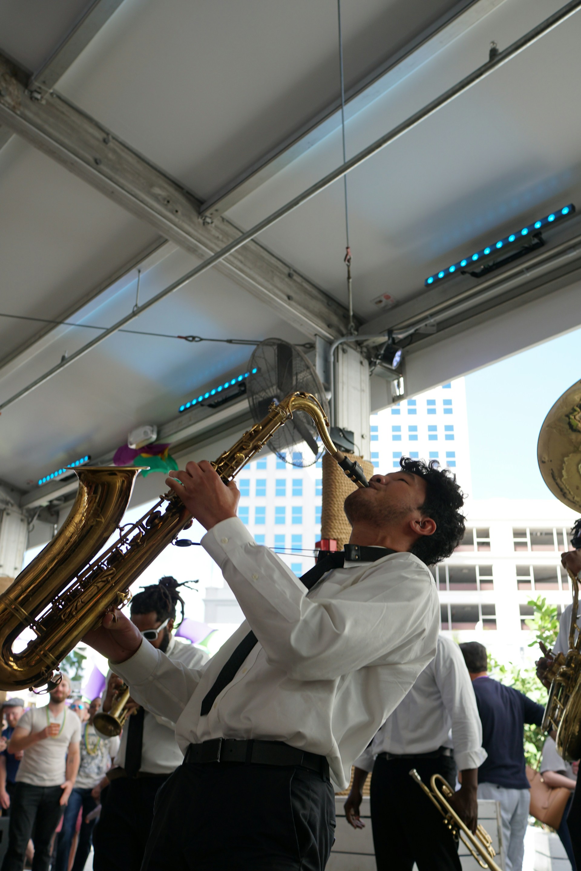 A saxophonist playing a smooth melody at a wedding reception with warm lighting and joyful guests.