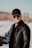 man in black leather jacket and black cap