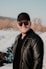 man in black leather jacket and black cap