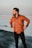 man in brown zip up jacket standing on beach during daytime
