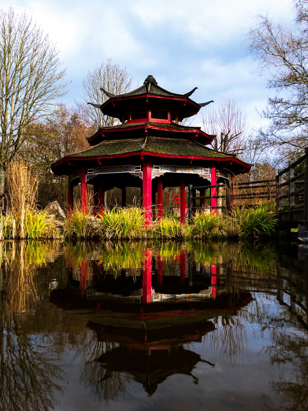 red and black temple near body of water during daytime