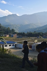 man in black jacket standing near green trees during daytime