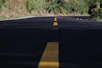black asphalt road between green grass field during daytime