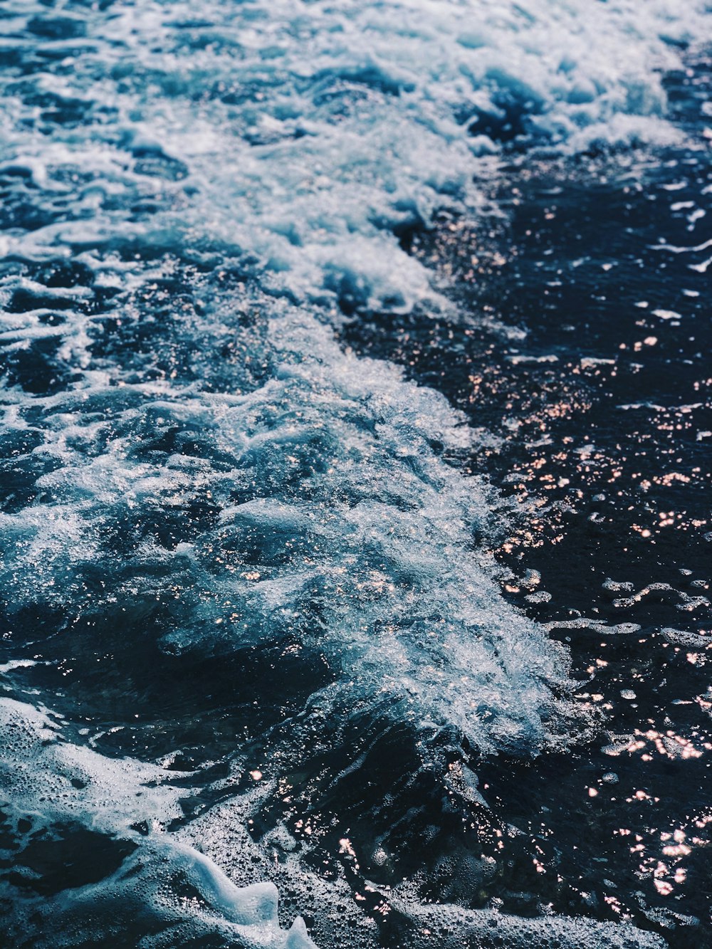 water waves on black sand during daytime