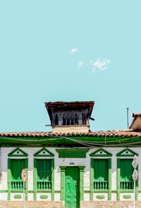 green and white concrete houses under white sky during daytime