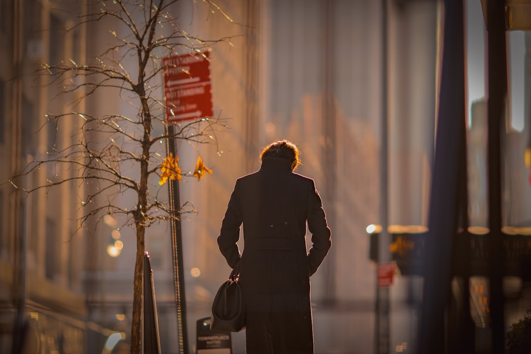 man in black coat standing near bare tree during daytime