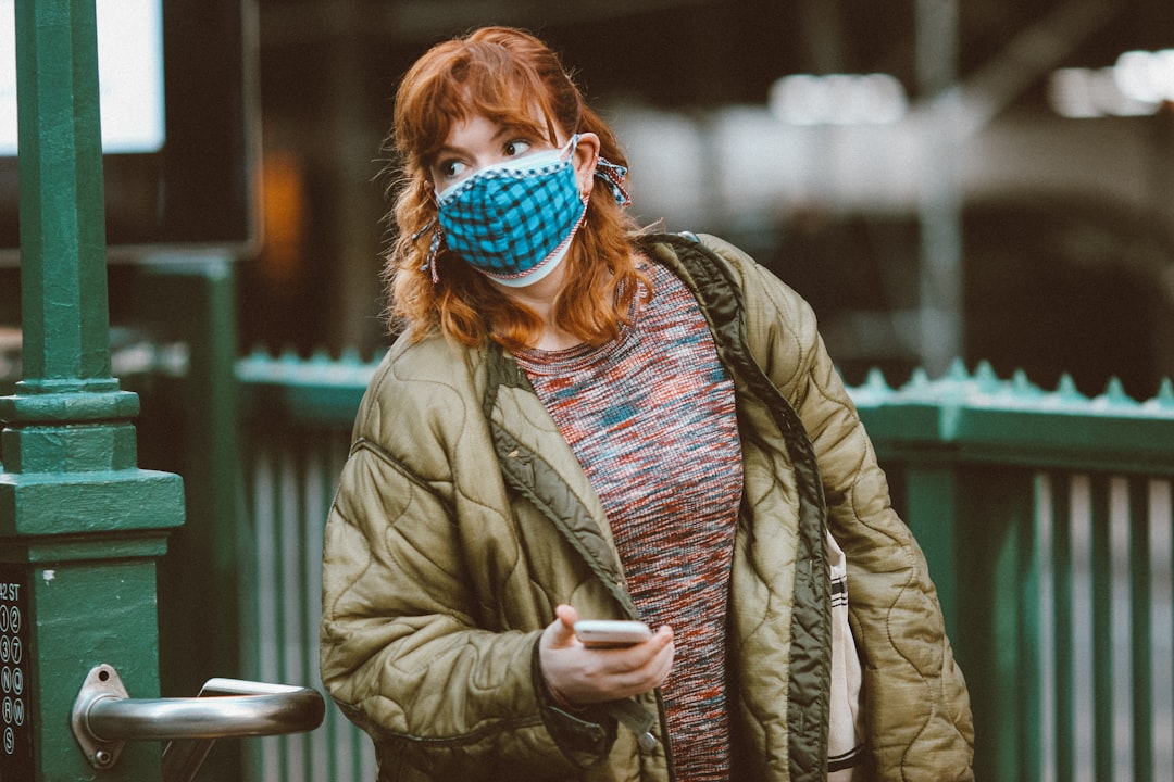 person in brown jacket wearing blue mask