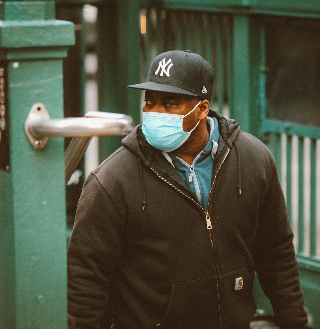 man in black zip up jacket and black fitted cap