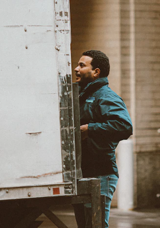 Close-up of a truck driver inspecting his vehicle before a long haul.