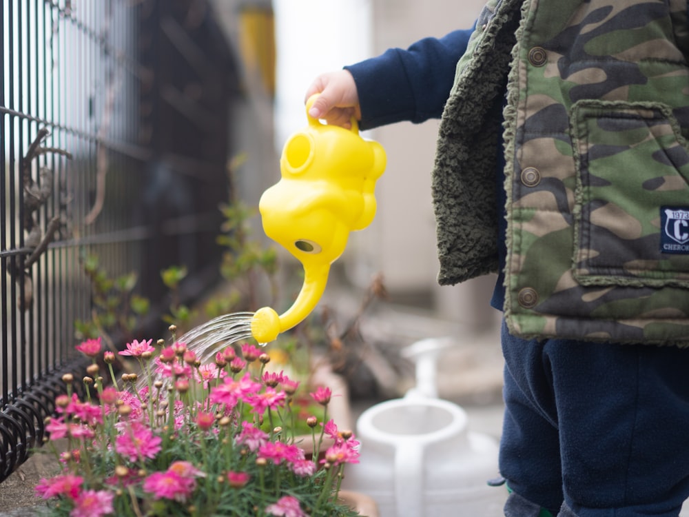 person in brown coat holding yellow balloon