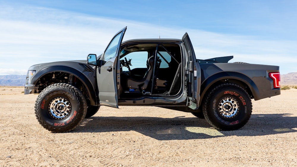 black classic car on brown sand during daytime