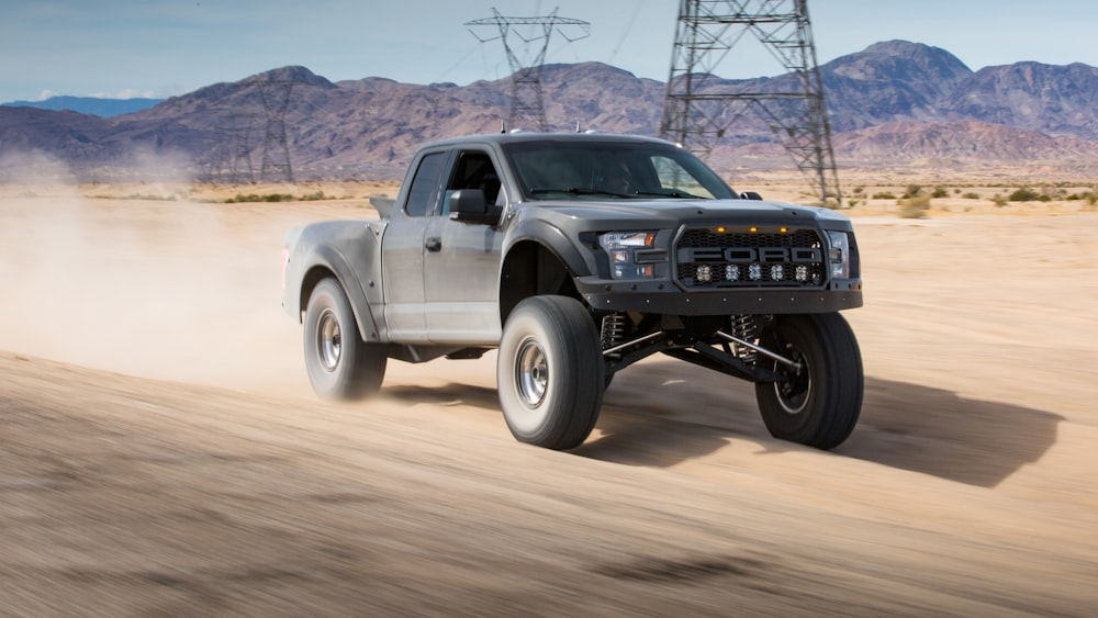 black chevrolet crew cab pickup truck on brown sand during daytime